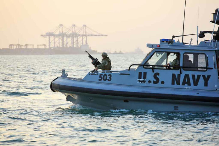 U.S. Navy patrol boat on water near industrial port.
