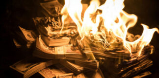 Burning stack of money in flames
