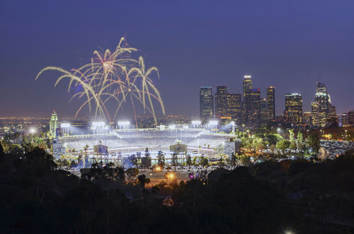 shutterstock521406034jpg Fireworks above a brightly lit stadium at night with city skyline