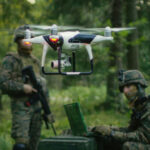 Soldiers in a forest operating a drone.