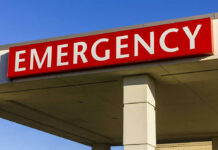 Red and white Emergency sign outside building.