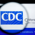 Magnifying glass over CDC logo on a website.