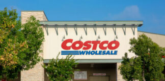 Costco Wholesale storefront with trees and empty shopping carts.