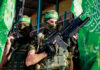 Charity Scam Funnels Cash To Hamas Two armed masked soldiers with green flags.