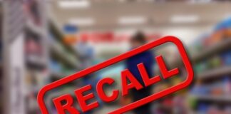 A blurred grocery store aisle with a prominent RECALL sign in red