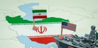 Map of Iran with Iranian and U.S. flags and a toy warship nearby