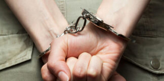 Person in handcuffs with hands behind back.