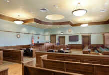 Arizona Manager Sentenced In Chip Trade-Secret Case Empty courtroom with wooden benches and desks.