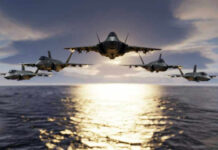 Five jets flying low over the ocean at sunset.