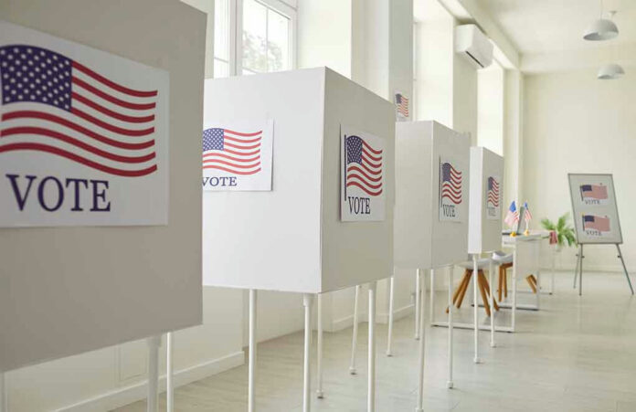 Voting booths with American flag signs.