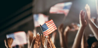 American flag held above a cheering crowd