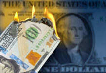 Burning US hundred-dollar bill with flames at the corner