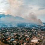 Aerial view of wildfire smoke over suburban town.