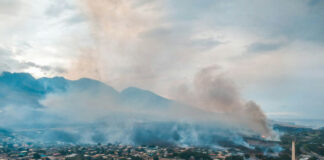Aerial view of wildfire smoke over suburban town.