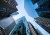 Main Street Boom Blindsides Investors Skyscrapers converging upward toward a clear sky