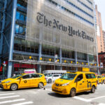 Busy street scene in New York City with yellow taxis and The New York Times building