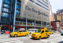Diversity Pushback Explodes at NYT Busy street scene in New York City with yellow taxis and The New York Times building