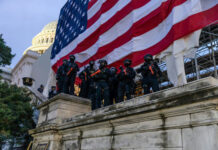 Washington Guard Mission Tested In Court Police in riot gear near U.S. Capitol building.