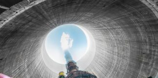 View from inside a cooling tower of a power plant, showing smoke and blue sky