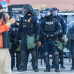 Police officers in riot gear standing in formation during a protest