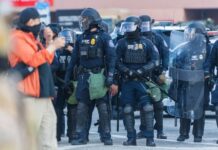 Minneapolis Killing Ignites ICE Firestorm Police officers in riot gear standing in formation during a protest