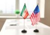 Mini flags of Iran and the United States on a conference table