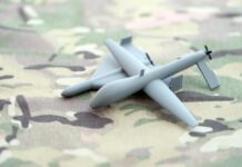 Small gray drone model on camouflage fabric