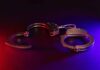 Handcuffs illuminated by red and blue lights.