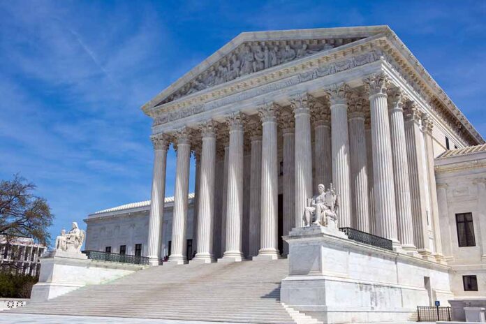 Supreme Court building with columns and statues outside.