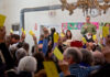 People holding up voting cards at a meeting.