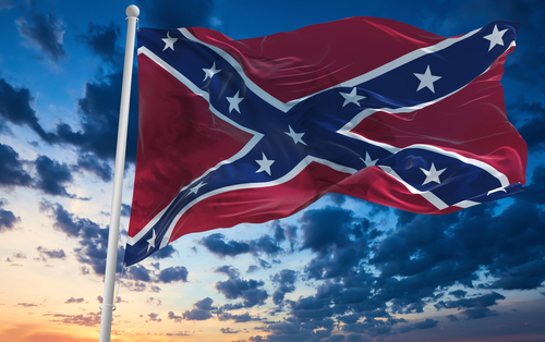 Confederate flag waving against a dramatic, cloudy sky.