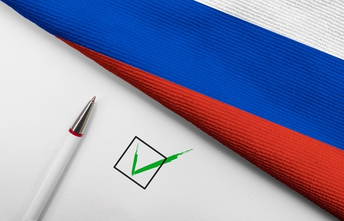 Russian flag, pen, and check mark on paper.