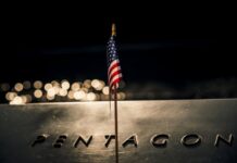 American flag on Pentagon memorial at night.