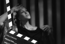 Black and white scene with clapboard and performer.