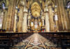 Interior of a grand cathedral with empty pews.