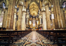 Interior of a grand cathedral with empty pews.