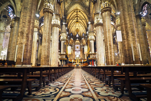 Interior of a grand cathedral with empty pews.